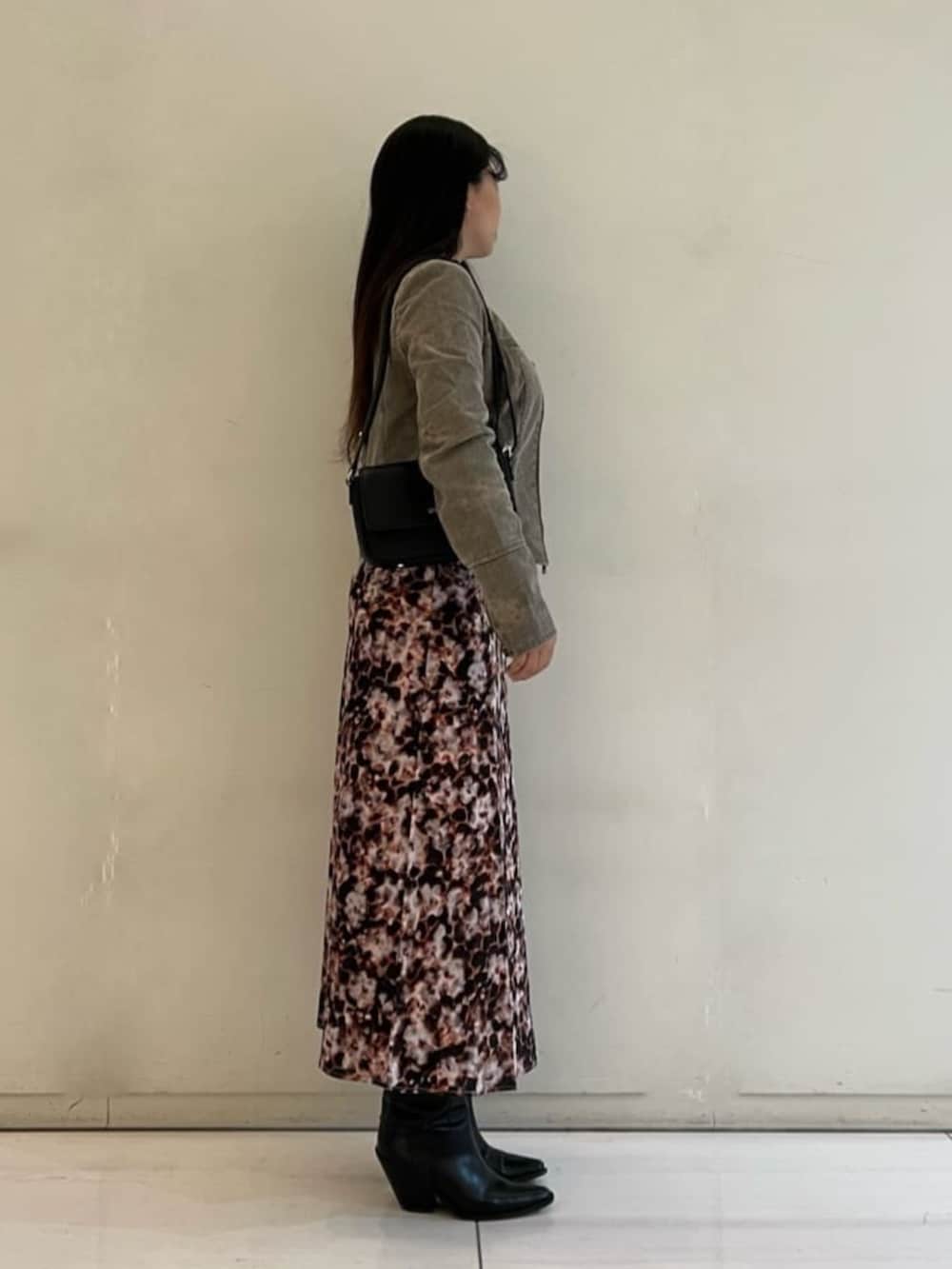 ベージュ系のノーカラージャケット、ブラック系のショルダーバッグ、ブラウン系のワンピースを着用したレディースの春コーディネートの3枚目の写真