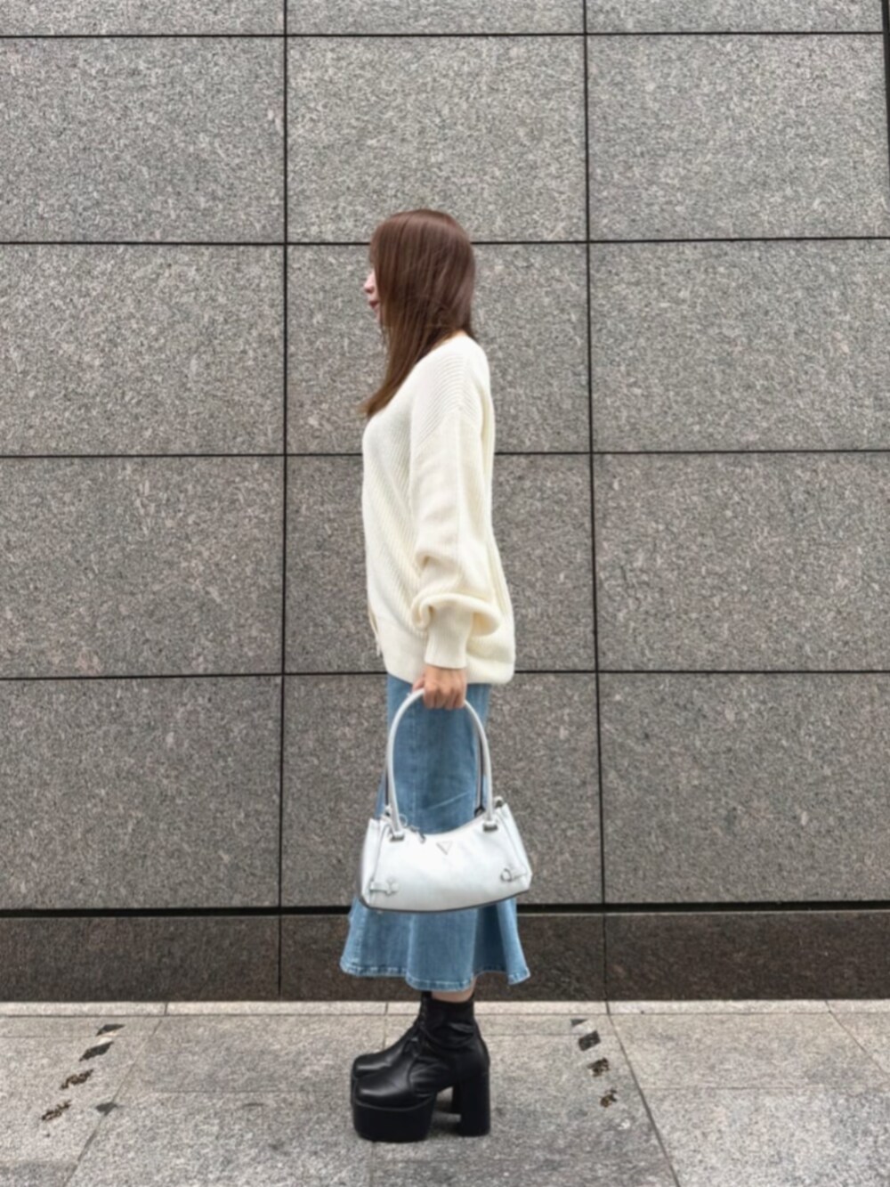 ブルー系のデニムスカート、シルバー系のショルダーバッグ、ベージュ系のカーディガン/ボレロを着用したレディースの秋コーディネートの3枚目の写真