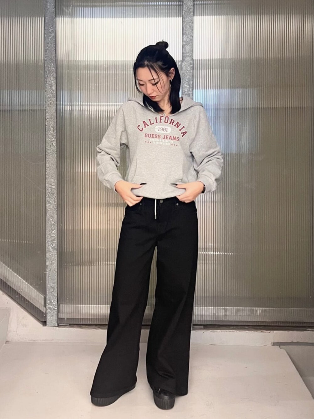 グレー系のパーカー、ブラック系のデニムパンツ、ブルー系のパーカーを着用したレディースの秋コーディネートの4枚目の写真