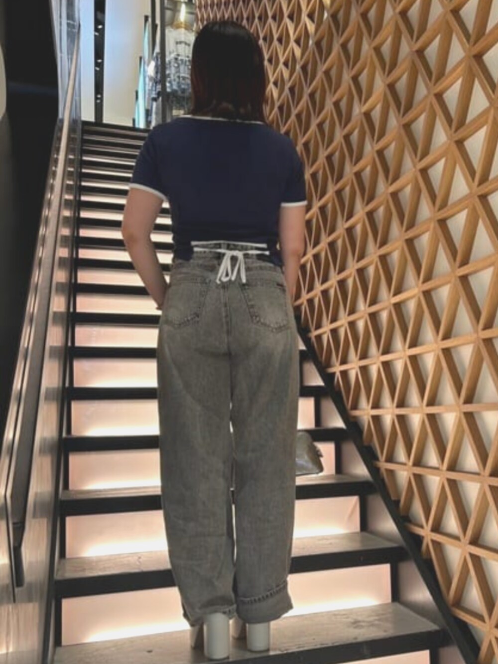 グレー系のショルダーバッグ、ブルー系のTシャツ/カットソー、グレー系のデニムパンツを着用したレディースの夏コーディネートの2枚目の写真