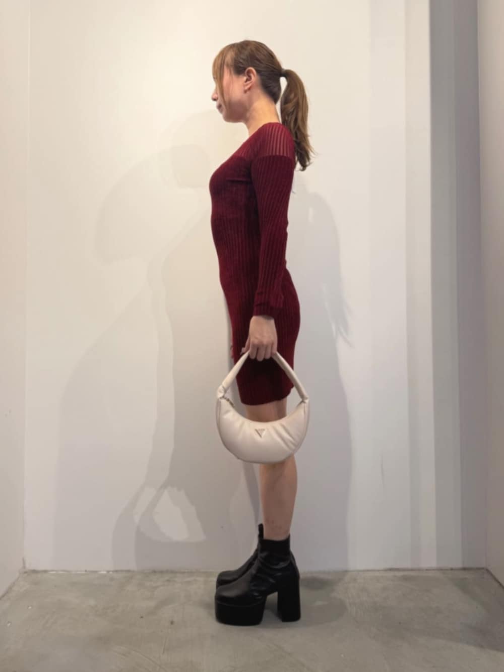 ホワイト系のショルダーバッグ、レッド系のワンピースを着用したレディースの冬コーディネートの3枚目の写真