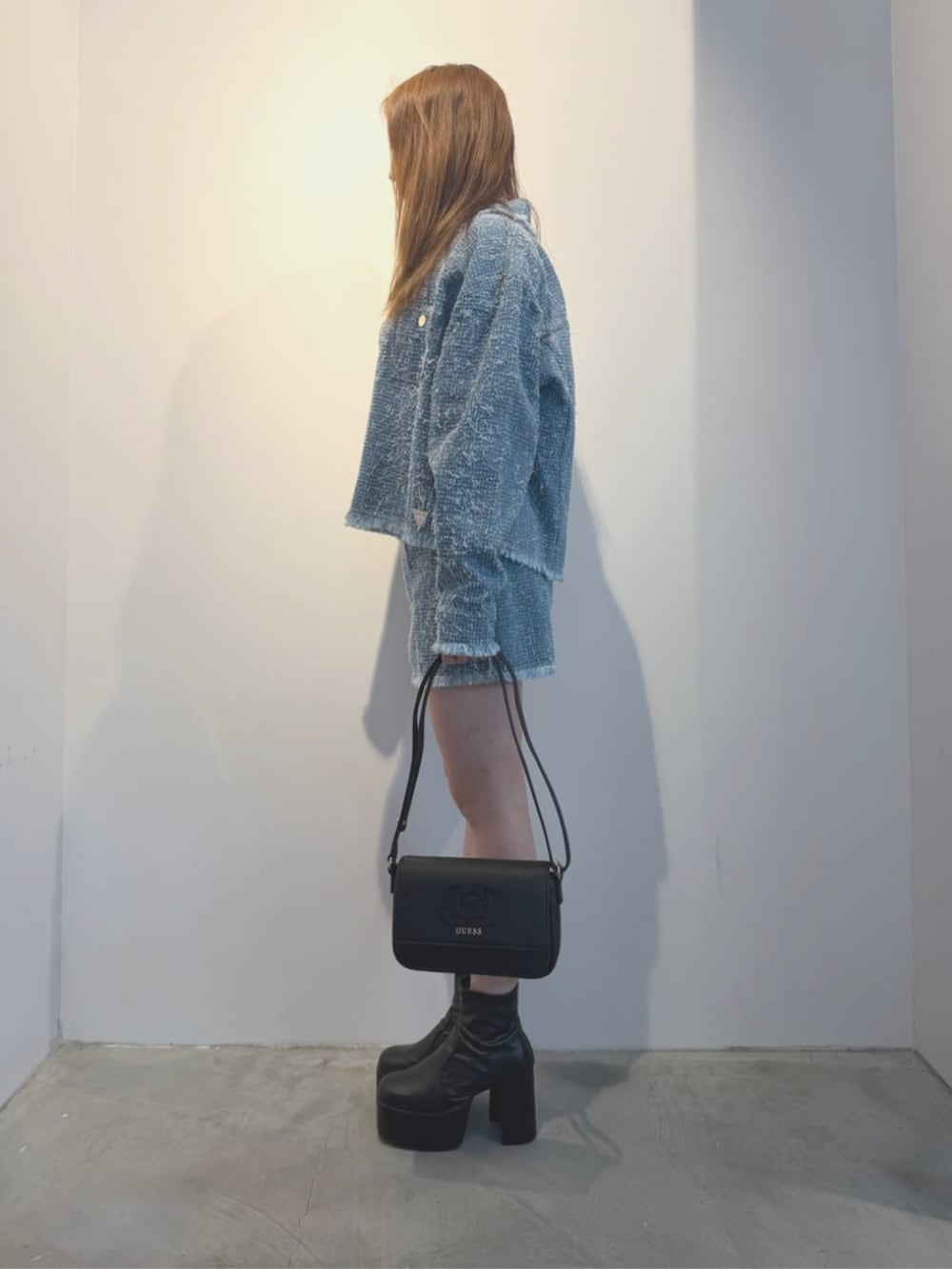 ブラック系のショルダーバッグ、ブルー系のTシャツ/カットソー、ブルー系のノーカラージャケットを着用したレディースの春コーディネートの3枚目の写真