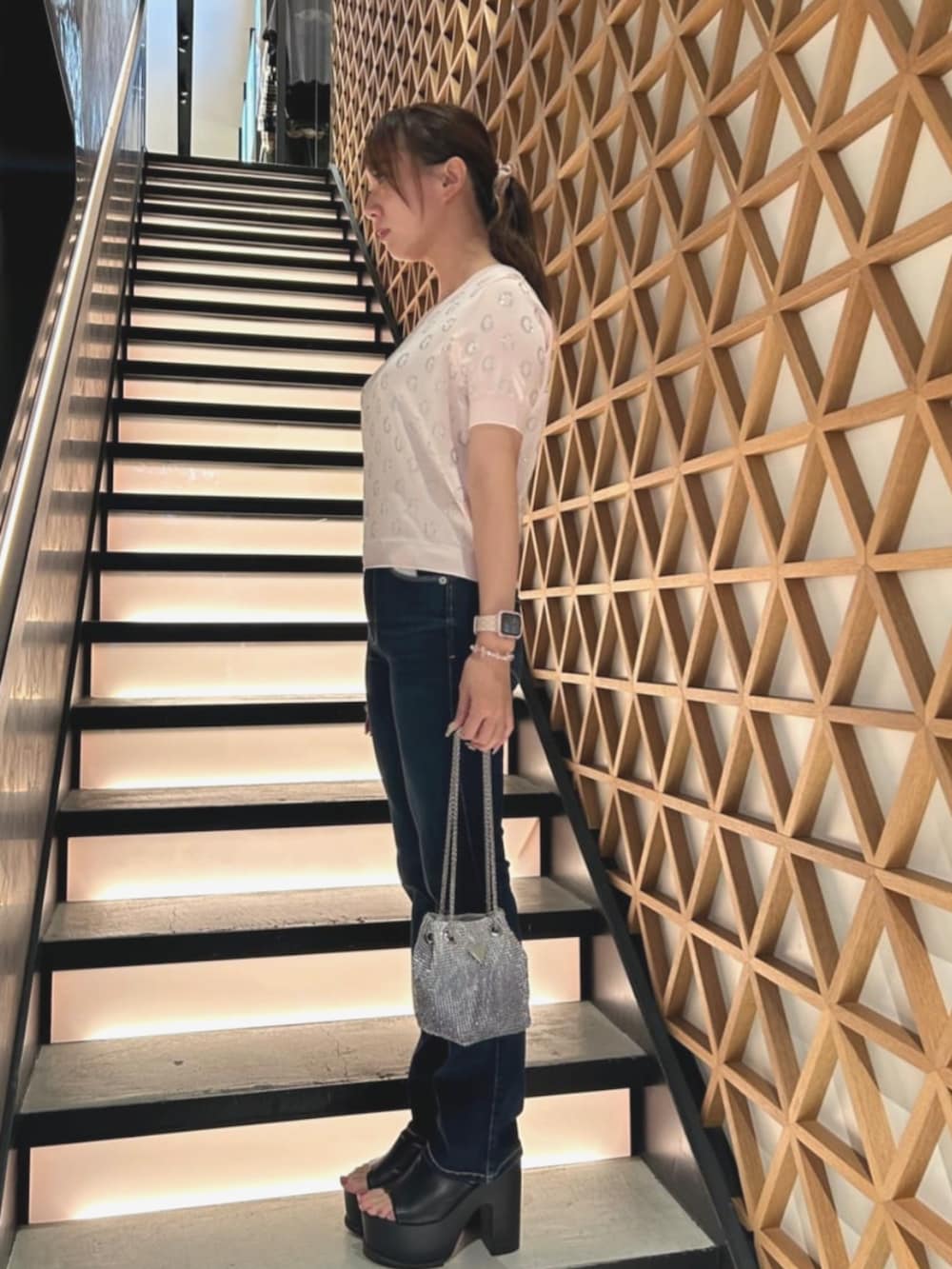 ブルー系のデニムパンツ、ピンク系のTシャツ/カットソー、シルバー系のショルダーバッグを着用したレディースの夏コーディネートの3枚目の写真