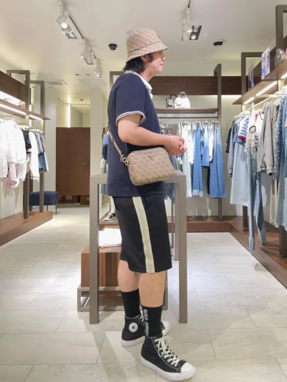 ベージュ系のショルダーバッグ、ブラック系のその他パンツ、ブルー系のポロシャツを着用したメンズの夏コーディネートの3枚目の写真