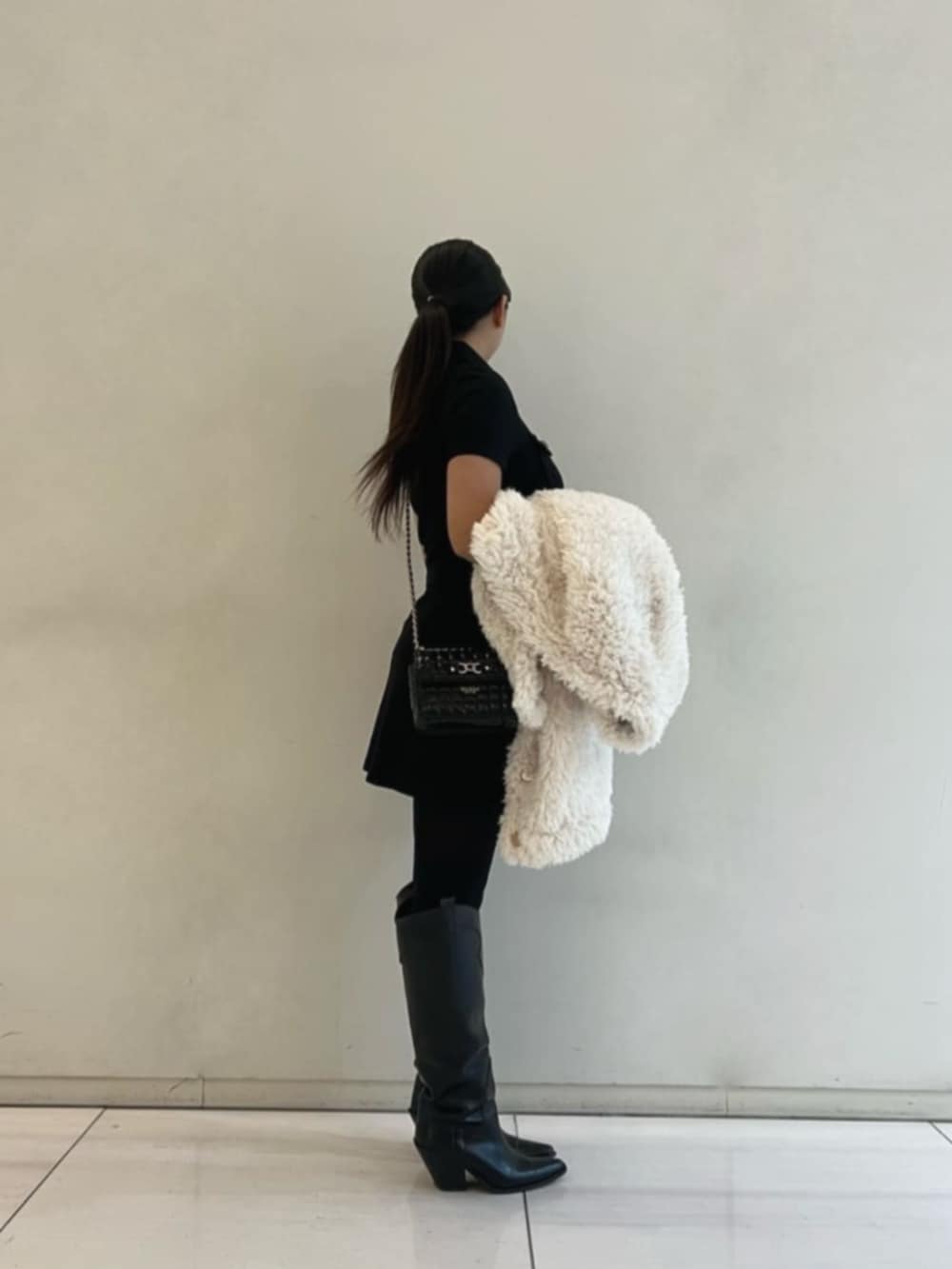 ブラック系のショルダーバッグ、ブラック系のスカート、ブラック系のシャツ/ブラウスを着用したレディースの冬コーディネートの3枚目の写真