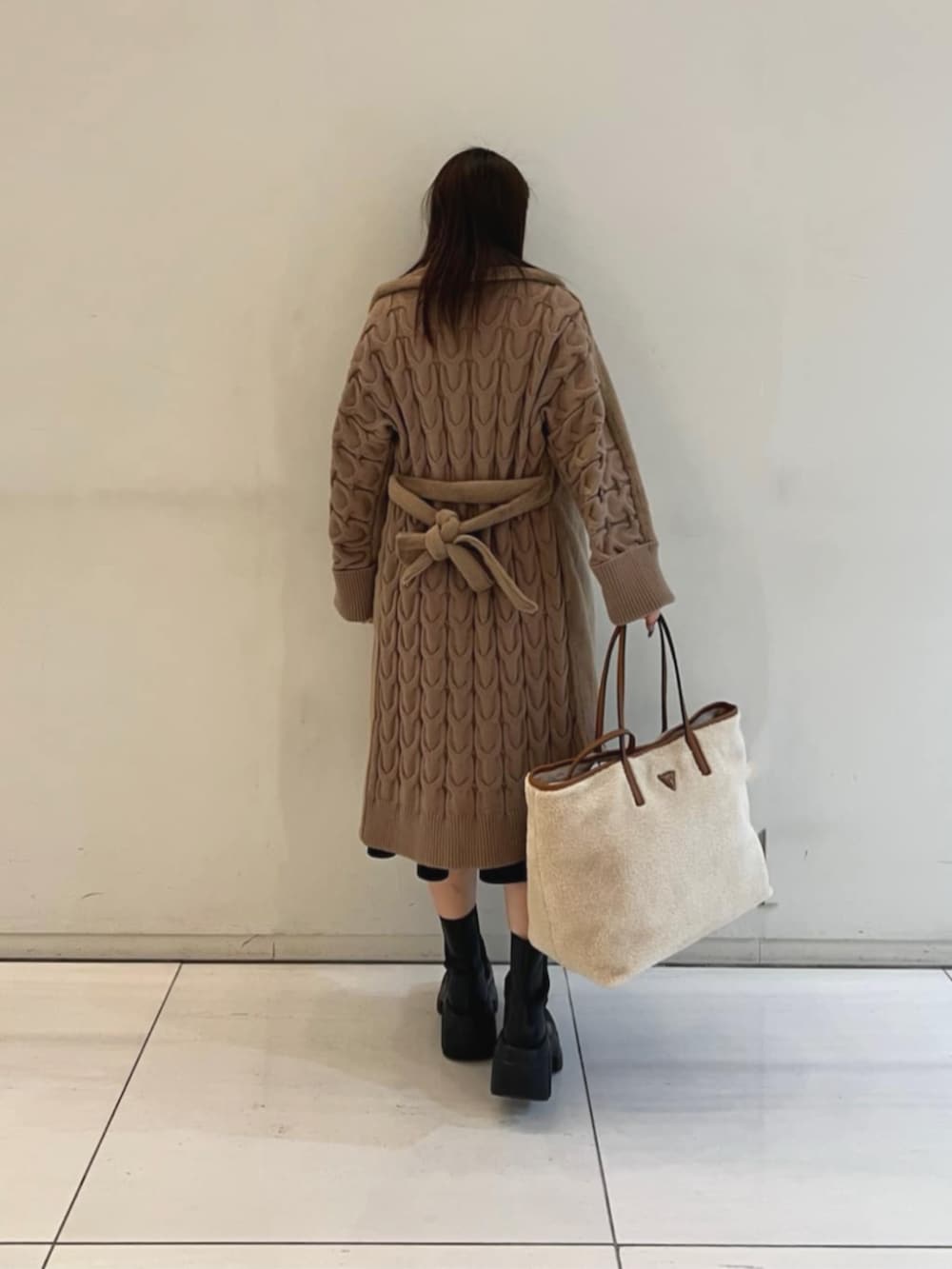 ブラック系のワンピース、ベージュ系のムートンコート、イエロー系のトートバッグを着用したレディースの冬コーディネートの2枚目の写真