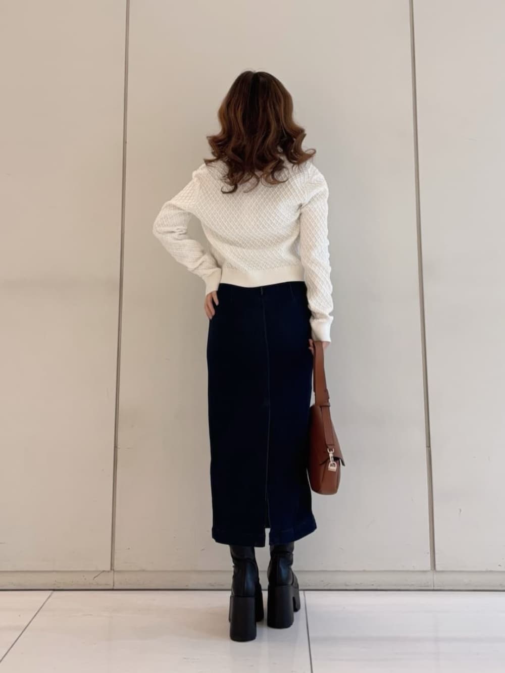 ブラウン系のショルダーバッグ、ブルー系のワンピース、ベージュ系のニット/セーターを着用したレディースの春コーディネートの2枚目の写真