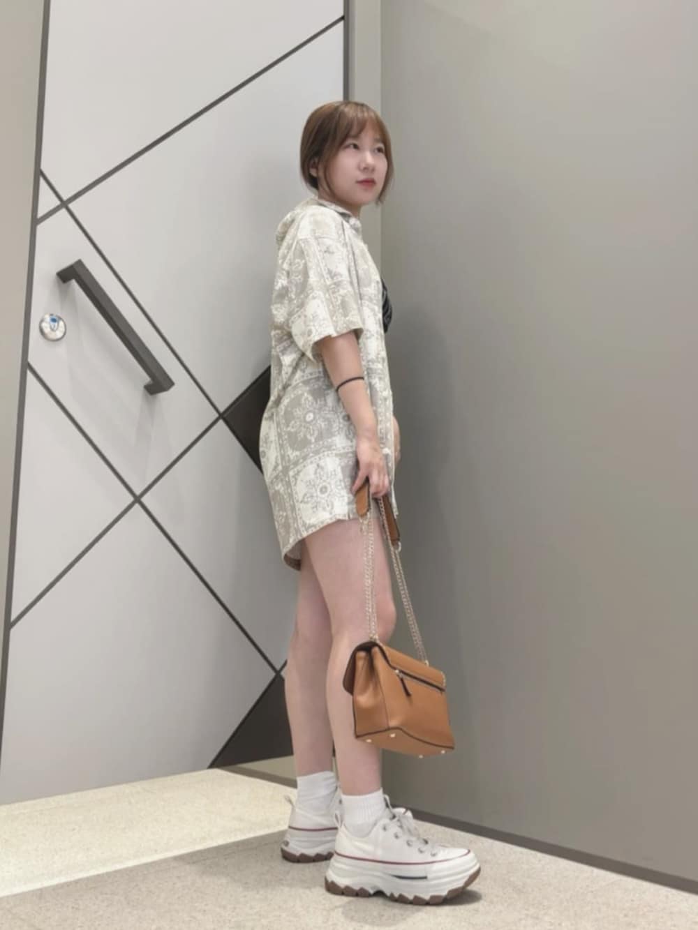 ベージュ系のシャツ/ブラウス、イエロー系のショルダーバッグ、ブラック系のタンクトップを着用したレディースの夏コーディネートの3枚目の写真