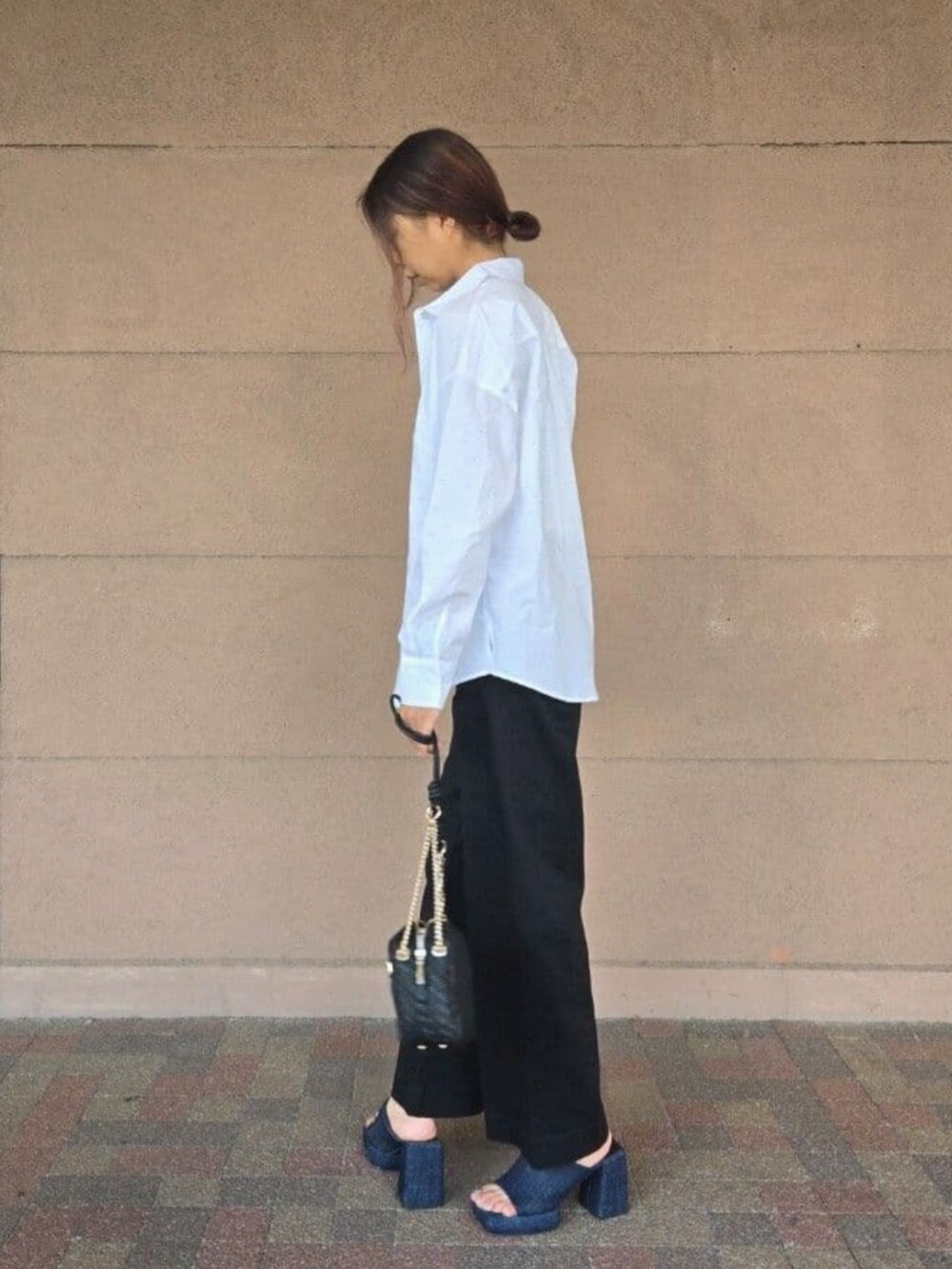 ブラック系のデニムパンツ、ホワイト系のタンクトップ、ホワイト系のシャツ/ブラウスを着用したレディースの夏コーディネートの3枚目の写真