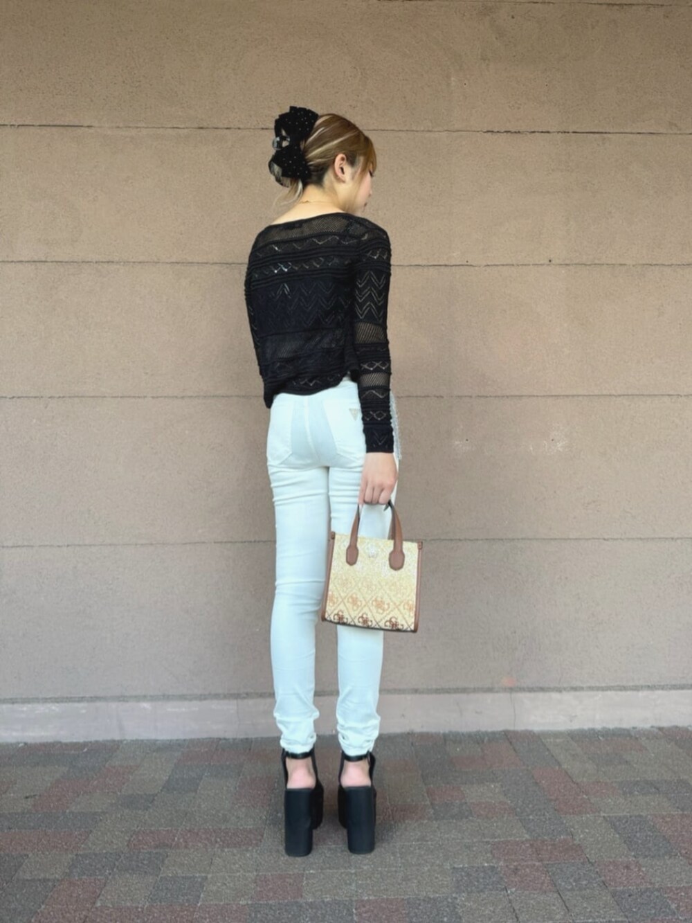 ブラウン系のショルダーバッグ、ホワイト系のデニムパンツ、ブラック系のカーディガン/ボレロを着用したレディースの夏コーディネートの2枚目の写真