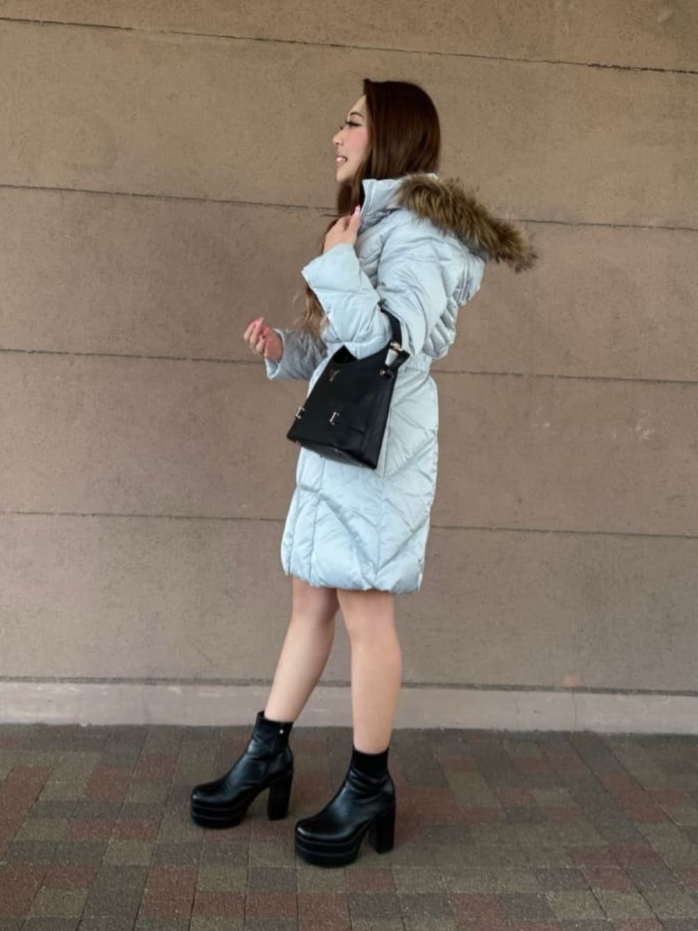 グレー系のダウンジャケット/コート、ブラック系のショルダーバッグを着用したレディースの春コーディネートの3枚目の写真