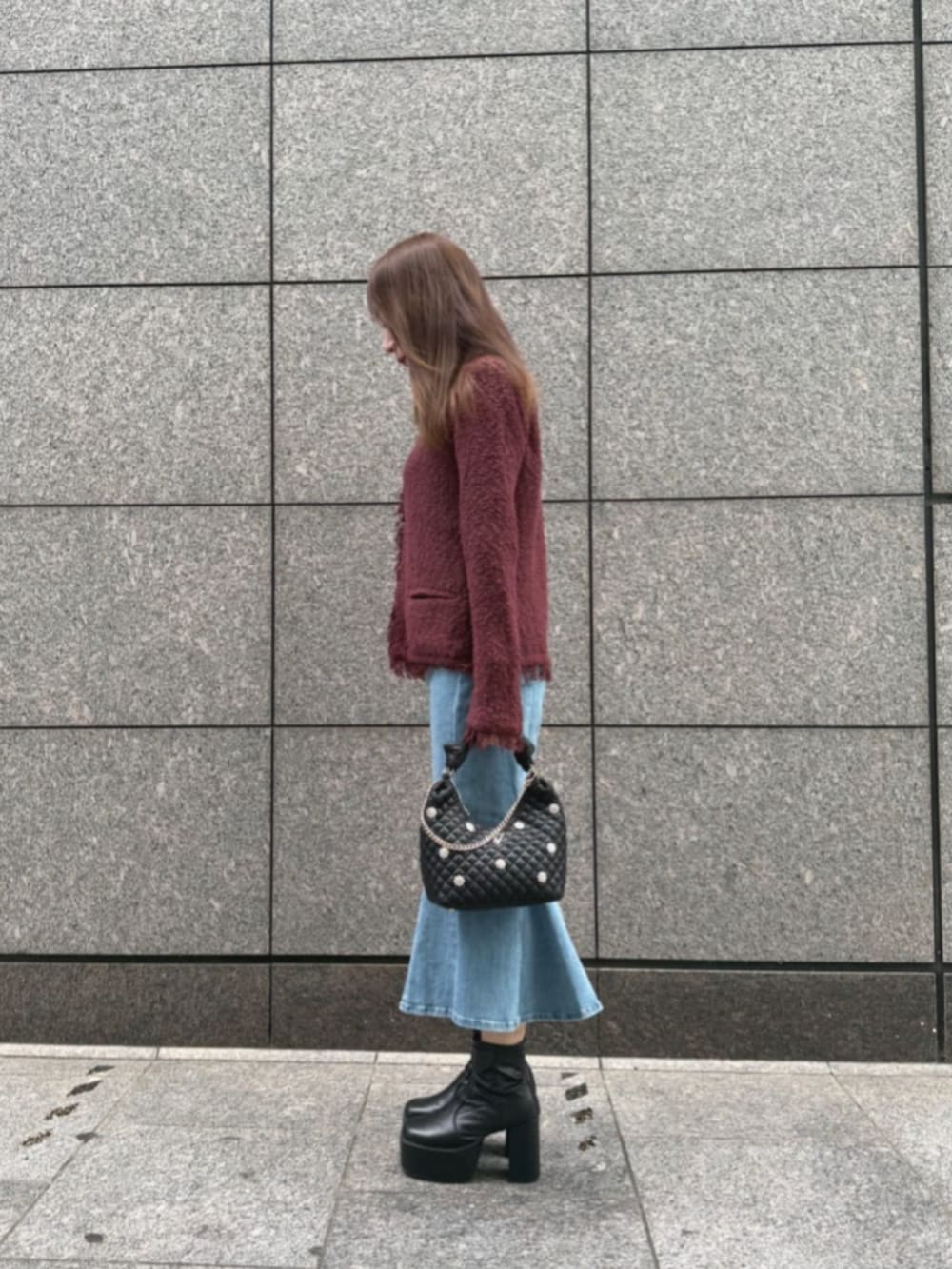 ブラック系のショルダーバッグ、ブルー系のデニムスカート、レッド系のノーカラージャケットを着用したレディースの秋コーディネートの3枚目の写真