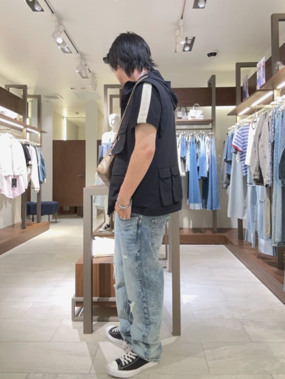 ベージュ系のショルダーバッグ、ブルー系のデニムパンツを着用したメンズの夏コーディネートの3枚目の写真