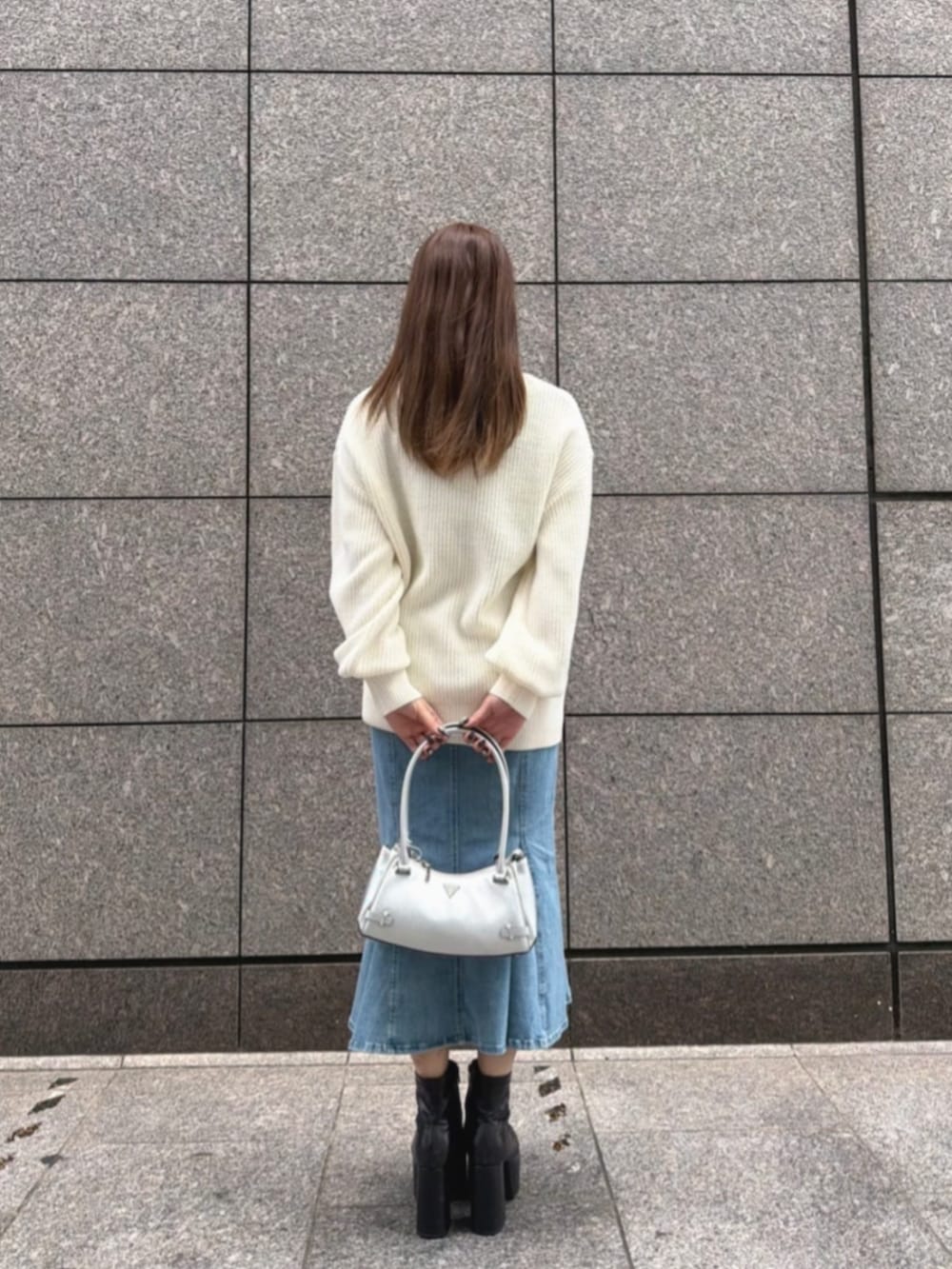 ブルー系のデニムスカート、シルバー系のショルダーバッグ、ベージュ系のカーディガン/ボレロを着用したレディースの秋コーディネートの2枚目の写真