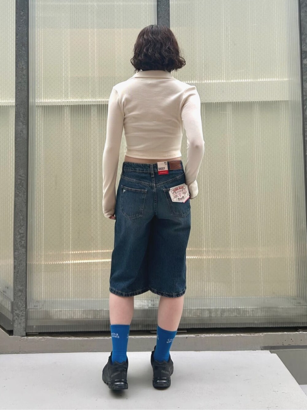 ブルー系のデニムパンツを着用したレディースの夏コーディネートの2枚目の写真