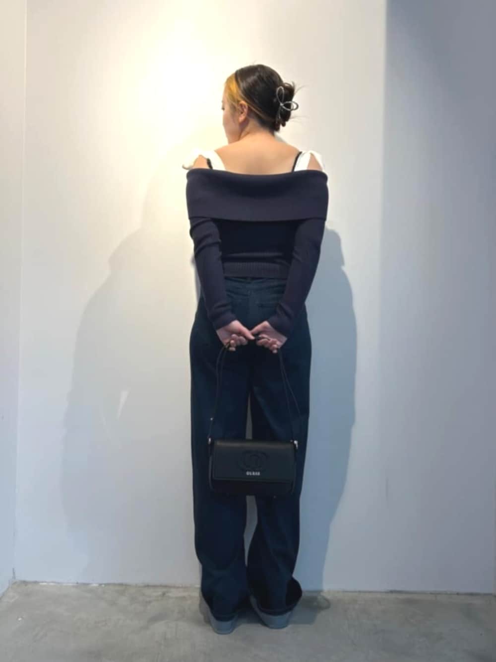 ブラック系のショルダーバッグ、ブルー系のデニムパンツ、ブルー系のTシャツ/カットソーを着用したレディースの春コーディネートの2枚目の写真