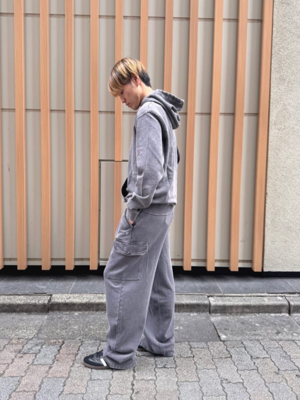 グレー系のパーカー、ブラック系のショルダーバッグを着用したメンズの秋コーディネートの3枚目の写真
