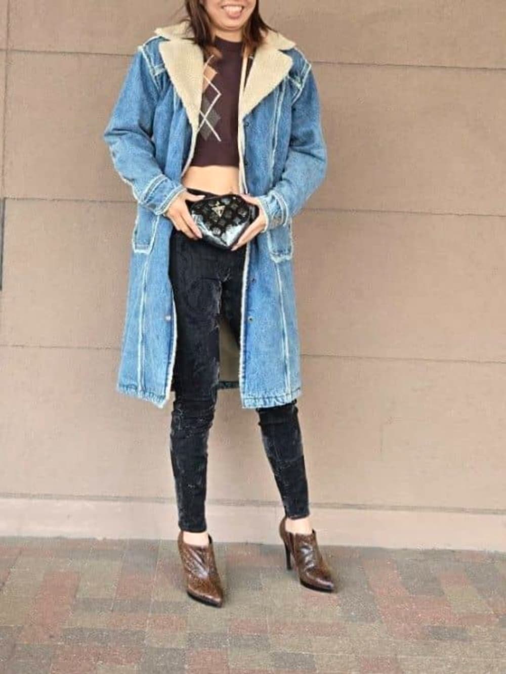 ブラック系のデニムパンツ、ブラウン系のニット/セーター、ブラック系のショルダーバッグを着用したレディースの春コーディネートの3枚目の写真