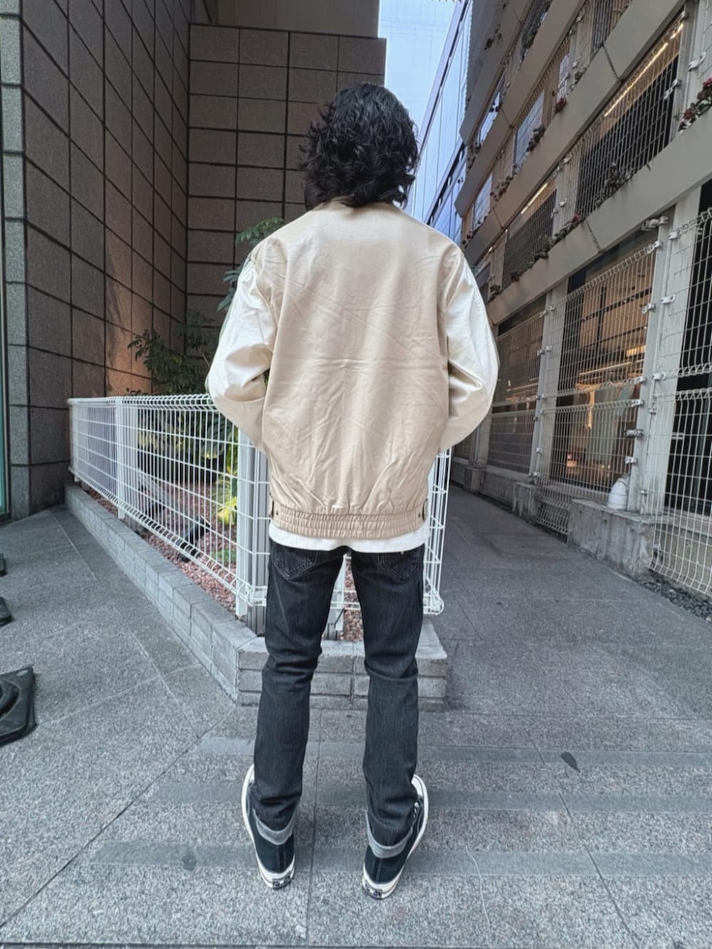 グレー系のデニムパンツ、ベージュ系のその他アウター、ホワイト系のタンクトップを着用したメンズの夏コーディネートの2枚目の写真