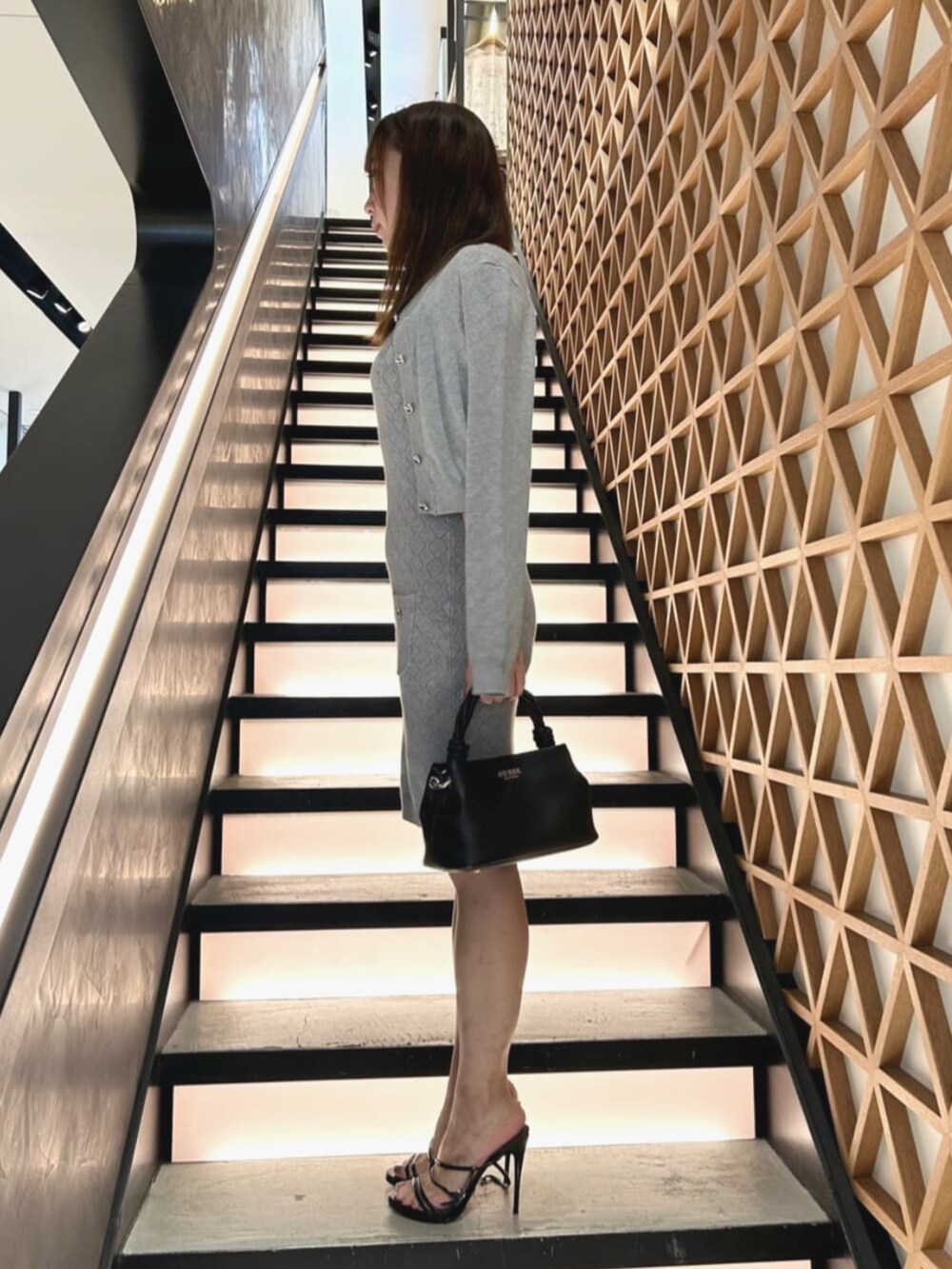 グレー系のワンピース、グレー系のカーディガン/ボレロ、ブラック系のショルダーバッグを着用したレディースの夏コーディネートの3枚目の写真