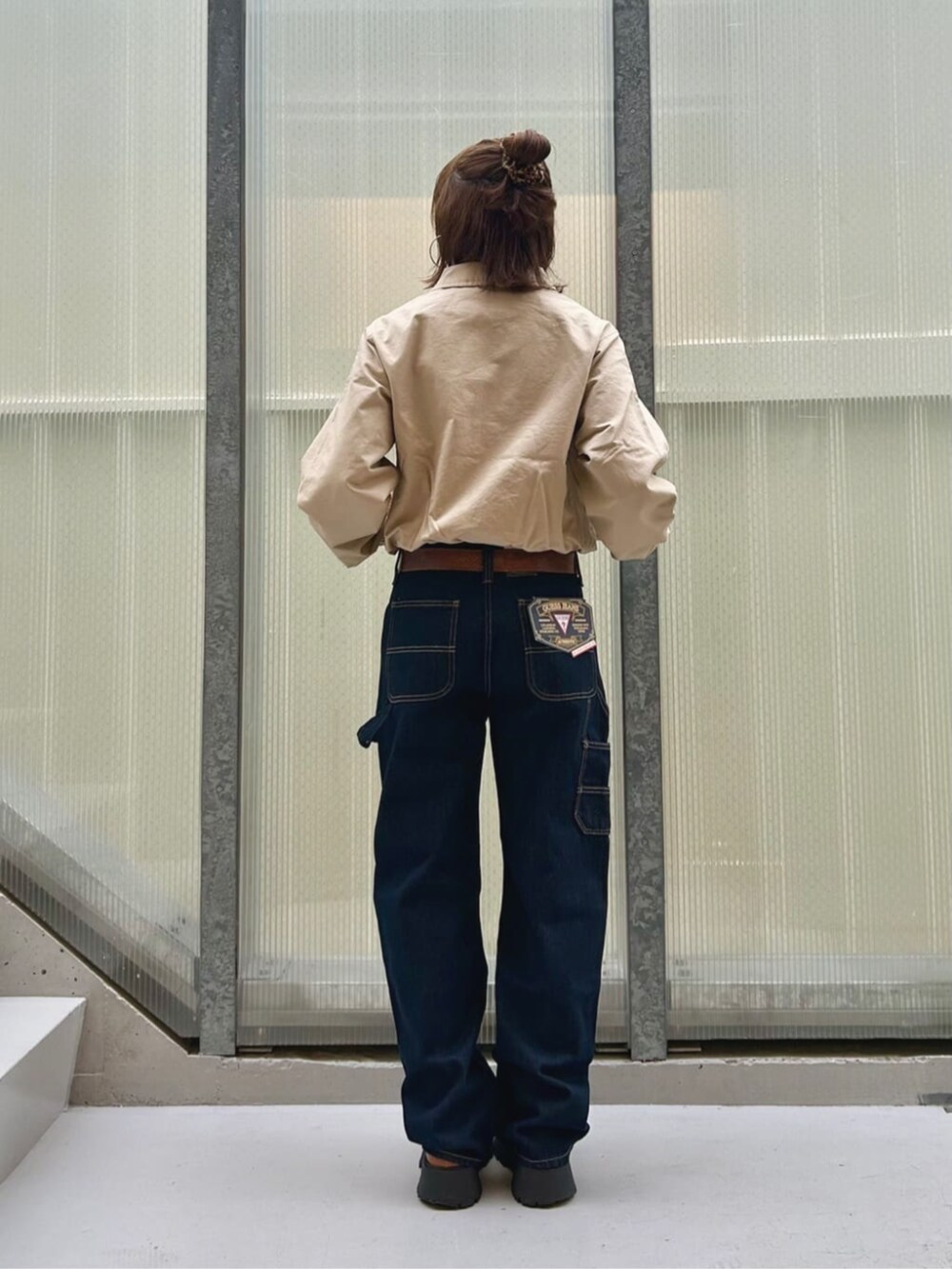 ベージュ系のその他アウター、ブルー系のデニムパンツを着用したレディースの秋コーディネートの2枚目の写真