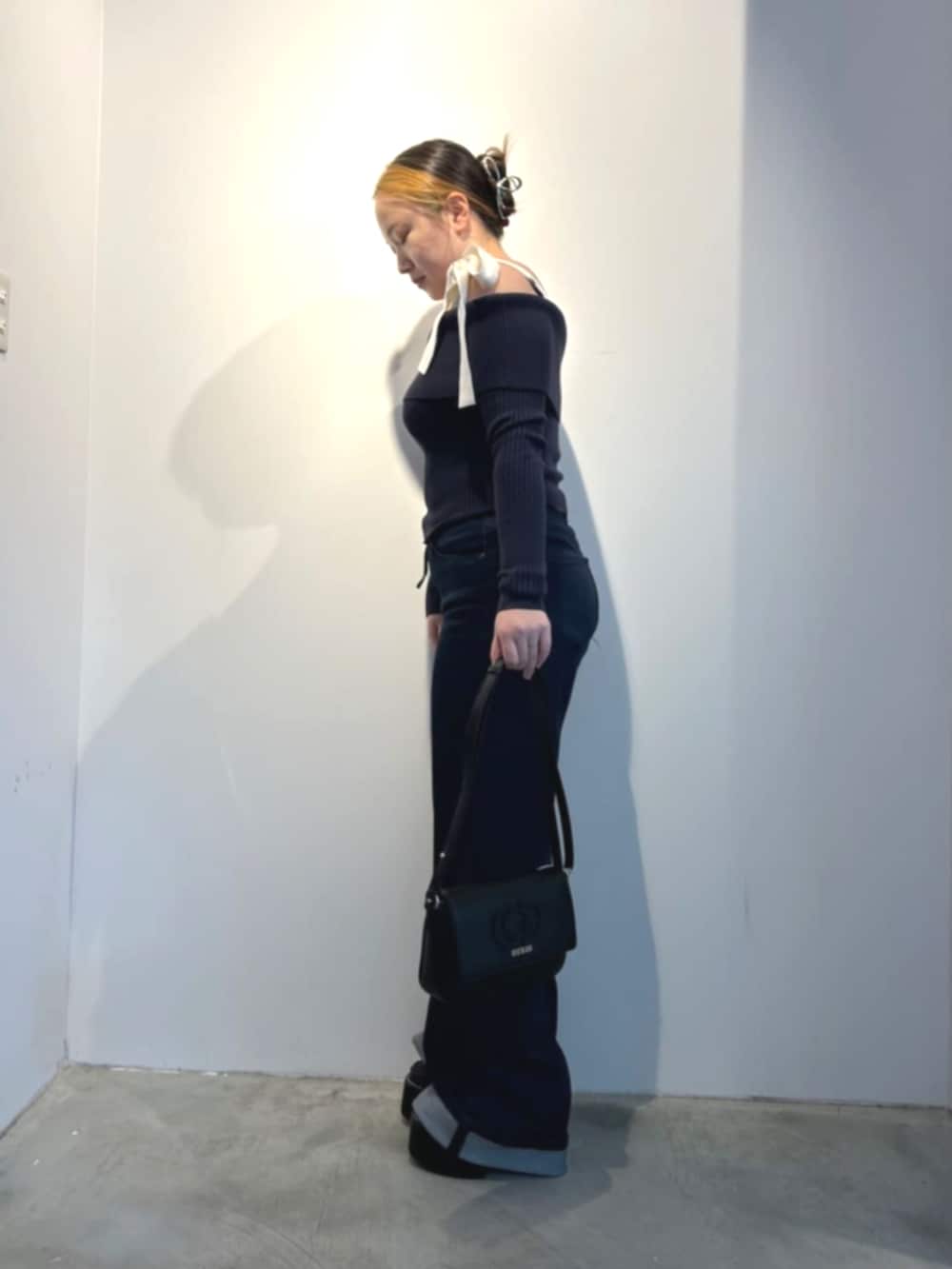 ブラック系のショルダーバッグ、ブルー系のデニムパンツ、ブルー系のTシャツ/カットソーを着用したレディースの春コーディネートの3枚目の写真