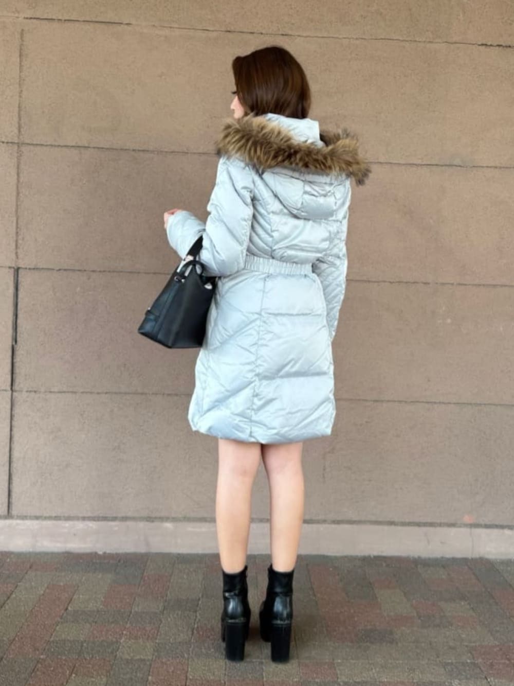 グレー系のダウンジャケット/コート、ブラック系のショルダーバッグを着用したレディースの春コーディネートの2枚目の写真