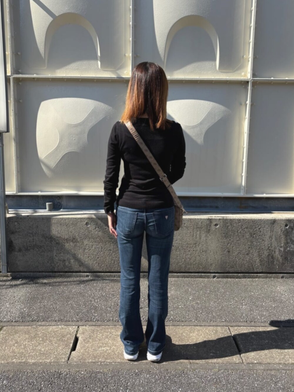 ベージュ系のショルダーバッグを着用したレディースの秋コーディネートの2枚目の写真