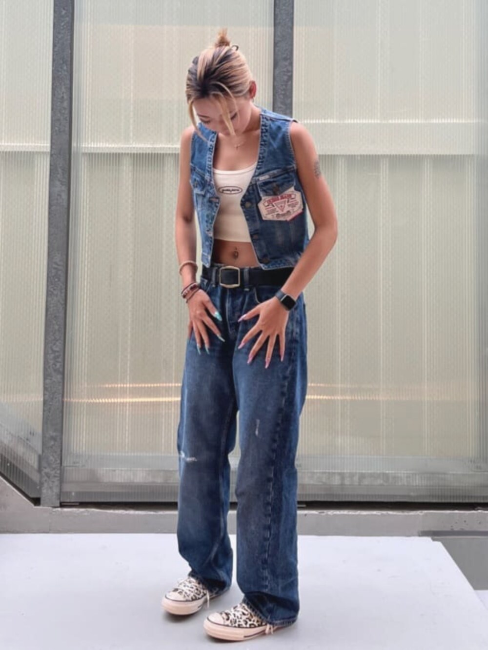 ブルー系のデニムパンツ、ブルー系のベストを着用したレディースの夏コーディネートの6枚目の写真