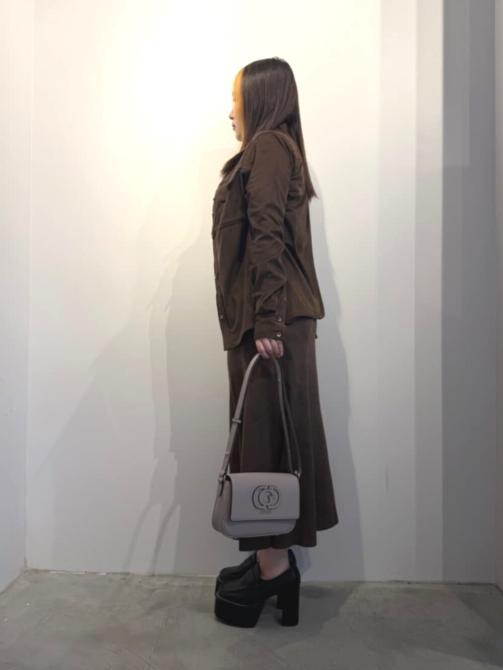 ベージュ系のショルダーバッグ、ブラウン系のその他トップス、ブラウン系のシャツ/ブラウスを着用したレディースの春コーディネートの3枚目の写真