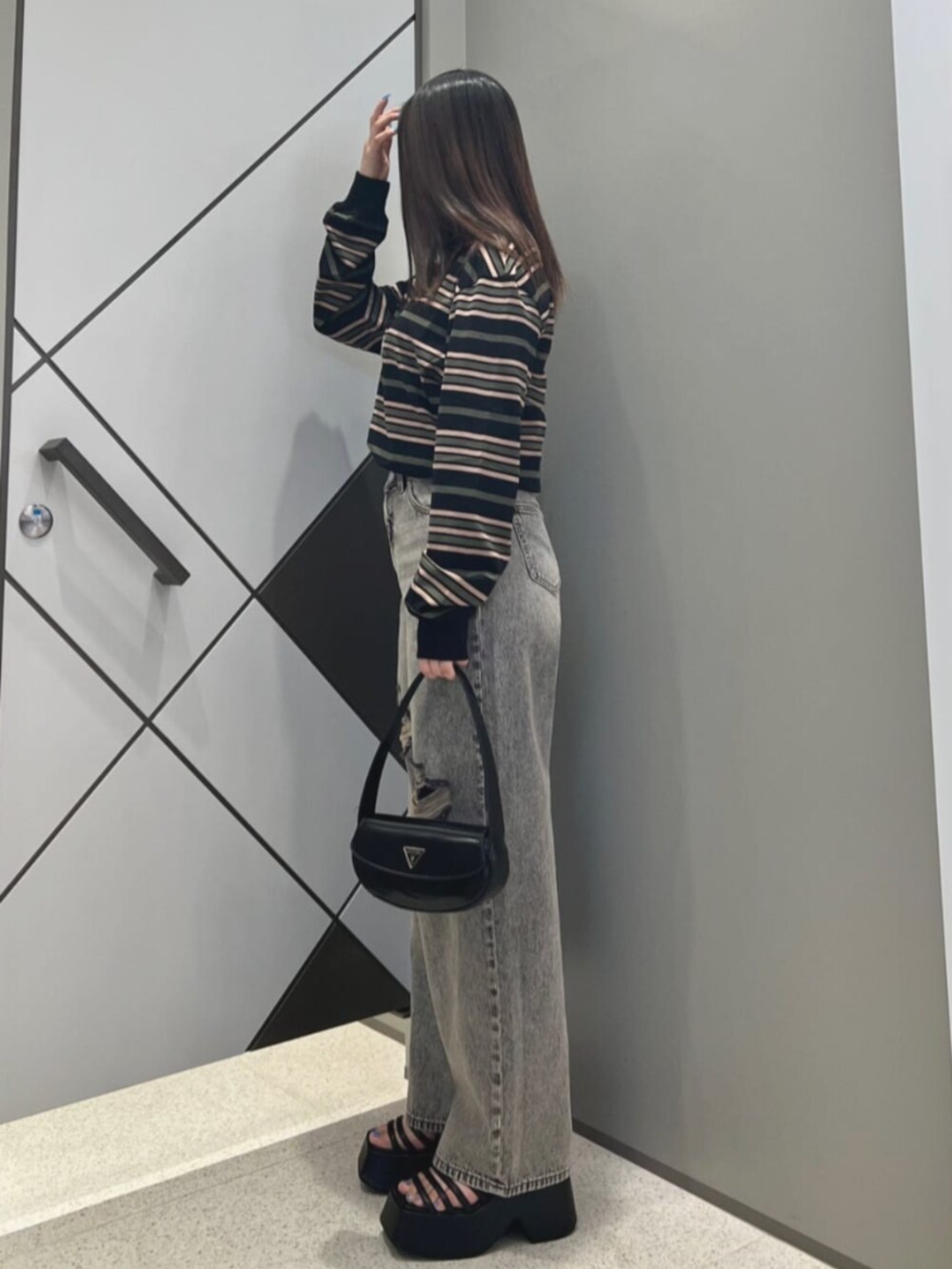 ブラック系のショルダーバッグ、ブラック系のTシャツ/カットソー、グレー系のデニムパンツを着用したレディースの夏コーディネートの3枚目の写真