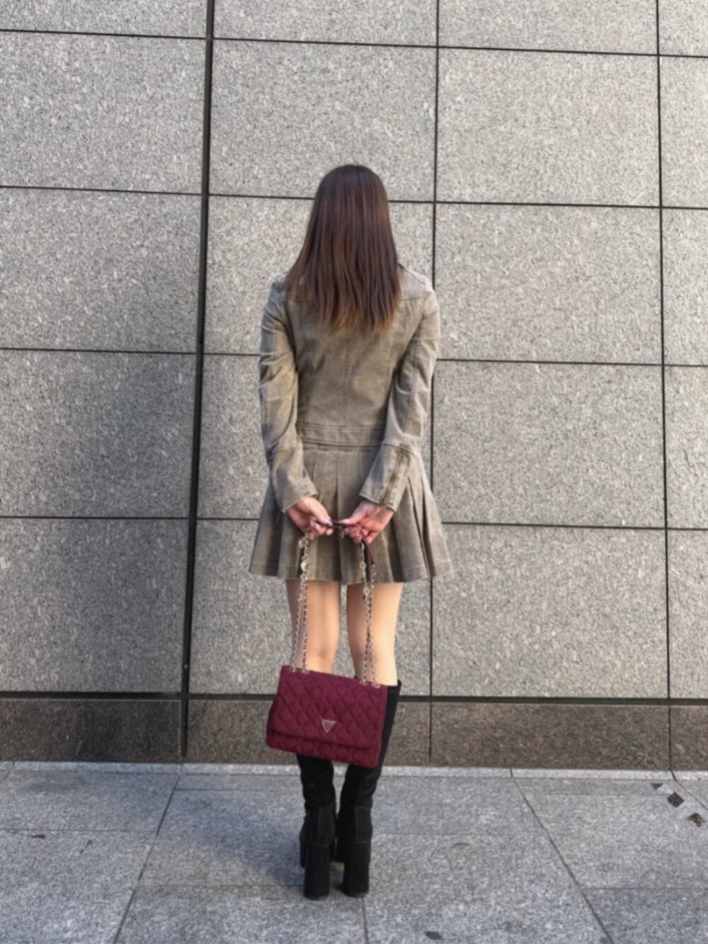 ベージュ系のノーカラージャケット、レッド系のショルダーバッグ、ベージュ系のスカートを着用したレディースの冬コーディネートの2枚目の写真