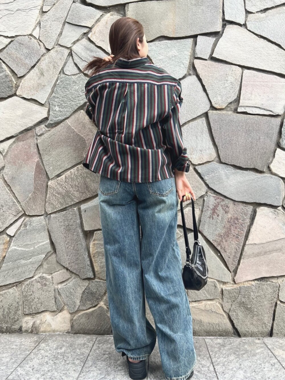 ブルー系のデニムパンツ、グレー系のタンクトップ、ブラック系のハンドバッグを着用したレディースの夏コーディネートの2枚目の写真