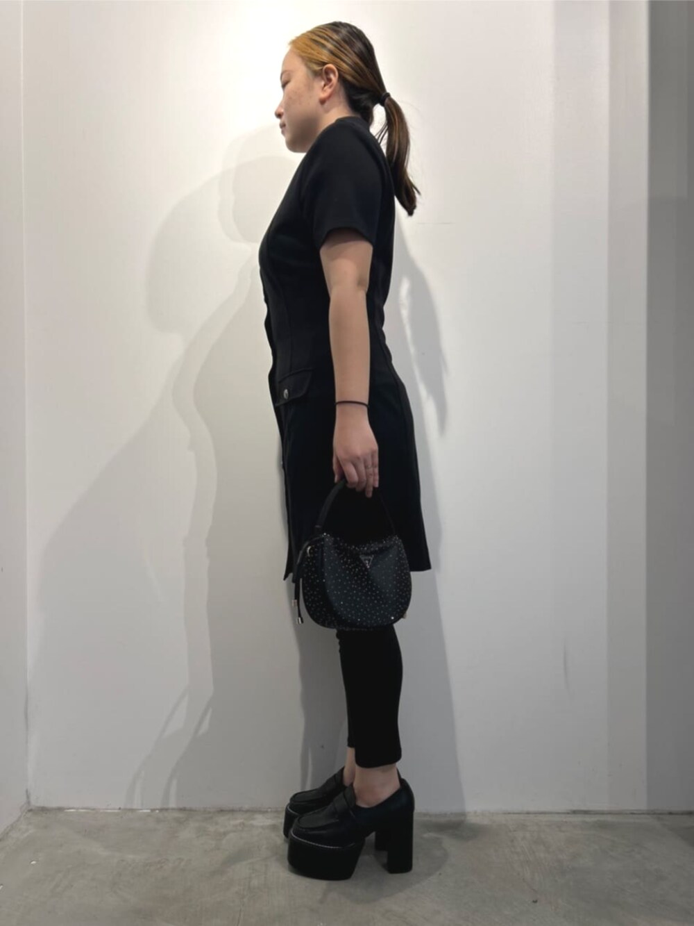 ブラック系のハンドバッグ、ブラック系のワンピースを着用したレディースの春コーディネートの3枚目の写真