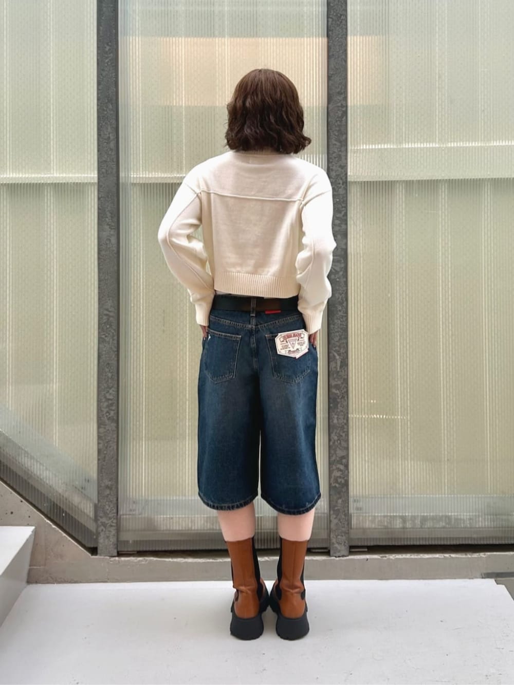 ブルー系のデニムパンツ、ホワイト系のニット/セーターを着用したレディースの秋コーディネートの2枚目の写真