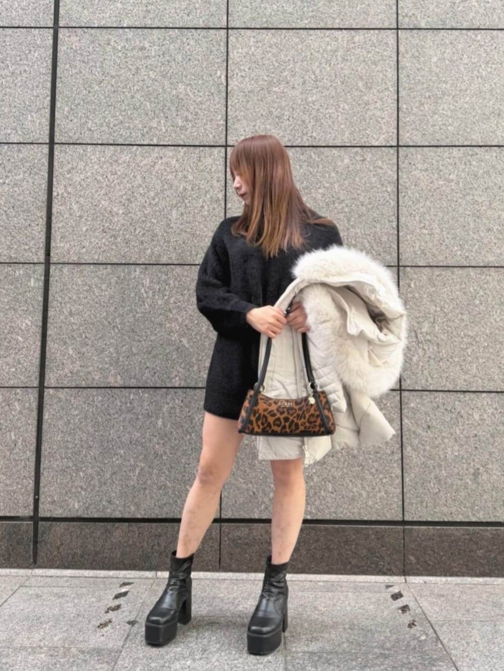 その他のハンドバッグ、ブラック系のニット/セーター、ホワイト系のダウンジャケット/コートを着用したレディースの冬コーディネートの4枚目の写真