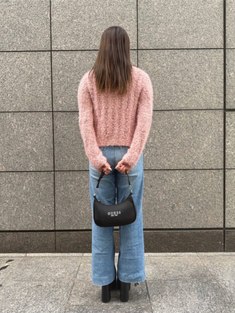 ブルー系のデニムパンツ、ブラック系のショルダーバッグ、ピンク系のキャミソールを着用したレディースの秋コーディネートの2枚目の写真