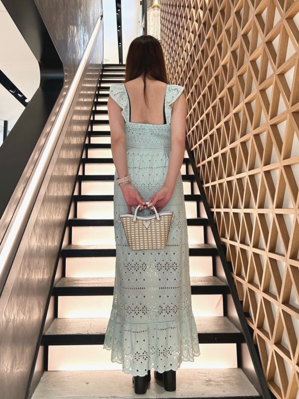 ホワイト系のショルダーバッグ、ブルー系のワンピースを着用したレディースの夏コーディネートの2枚目の写真