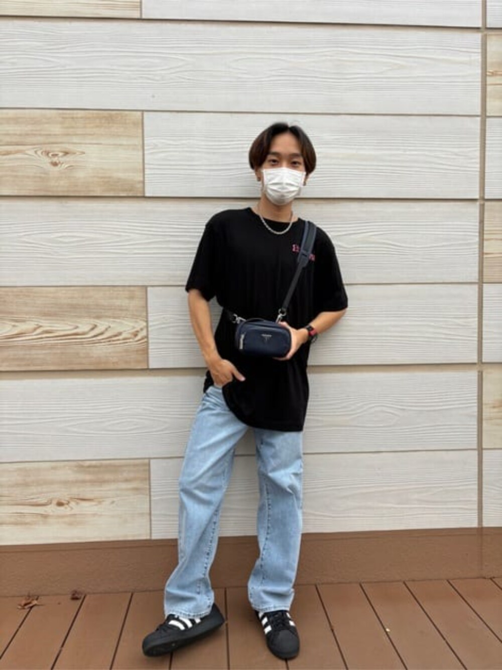 ブルー系のデニムパンツ、ブラック系のTシャツ/カットソー、ブルー系のショルダーバッグを着用したメンズの秋コーディネートの2枚目の写真