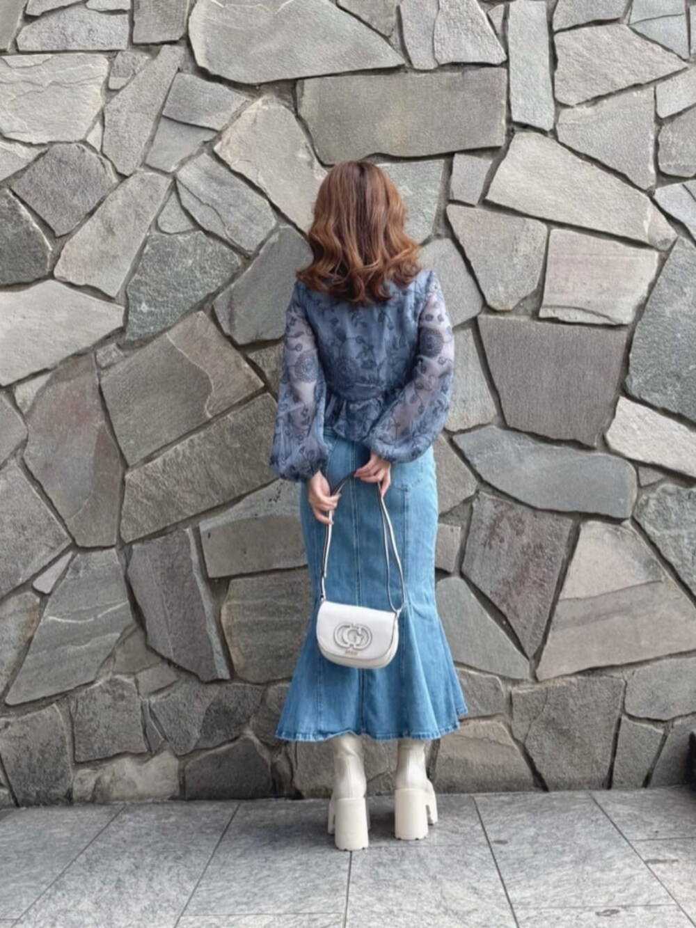 ホワイト系のショルダーバッグ、ブルー系のシャツ/ブラウス、ブルー系のデニムスカートを着用したレディースの秋コーディネートの2枚目の写真