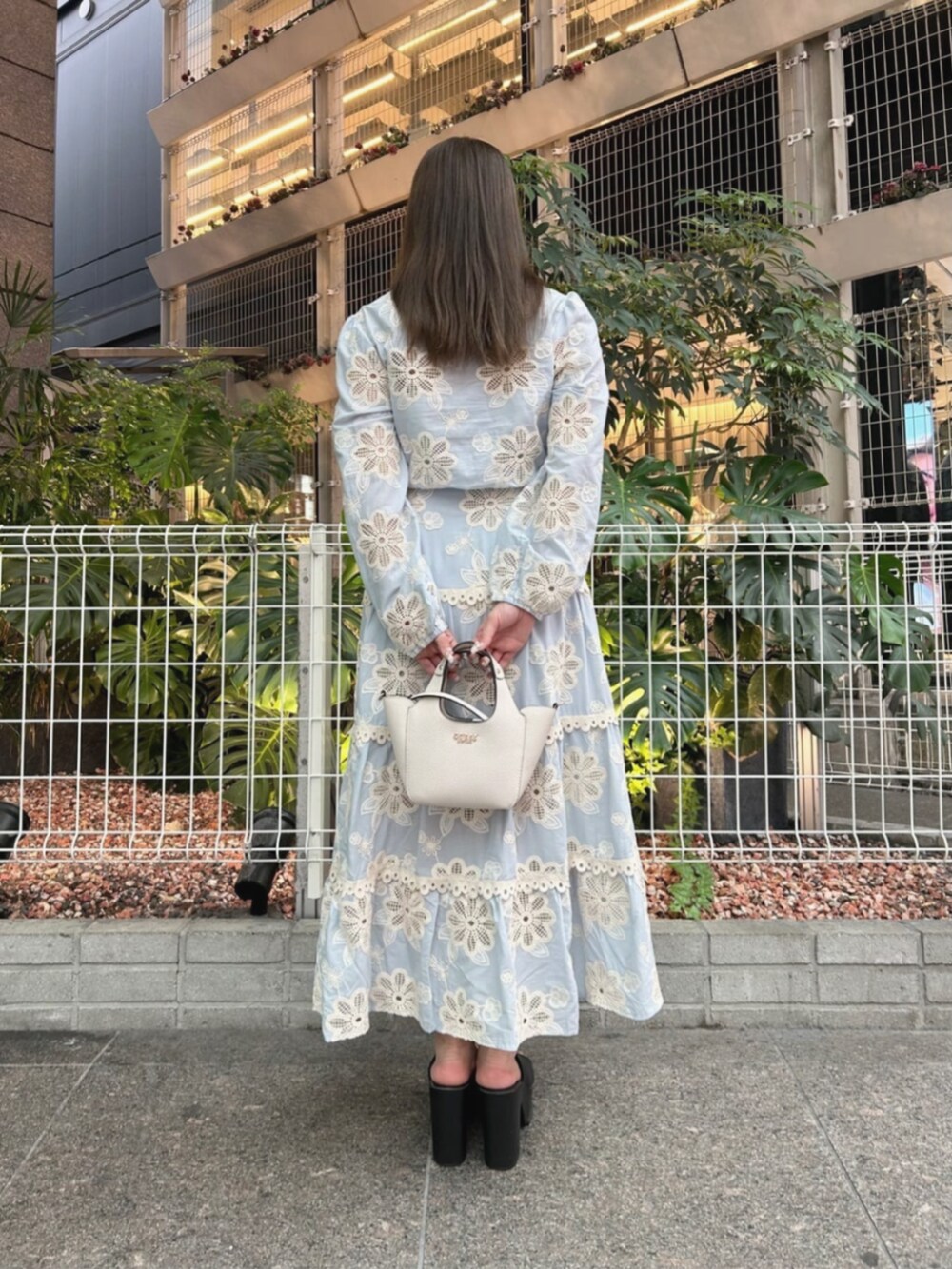 ホワイト系のショルダーバッグ、ブルー系のワンピース、ブルー系のシャツ/ブラウスを着用したレディースの秋コーディネートの2枚目の写真