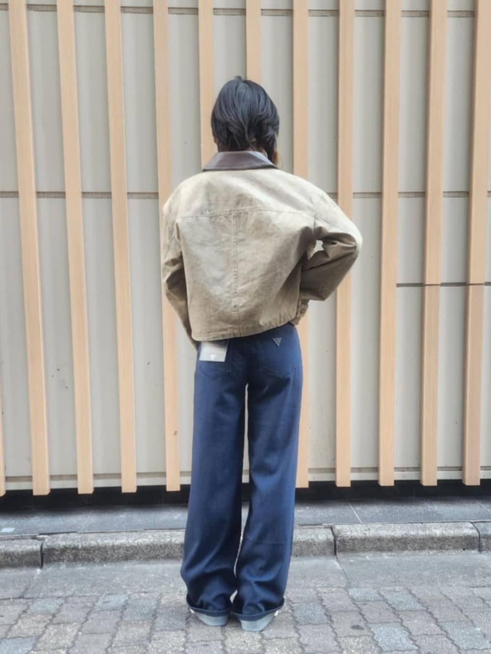 ホワイト系のTシャツ/カットソー、ブルー系のデニムパンツ、グリーン系のミリタリージャケットを着用したレディースの冬コーディネートの2枚目の写真