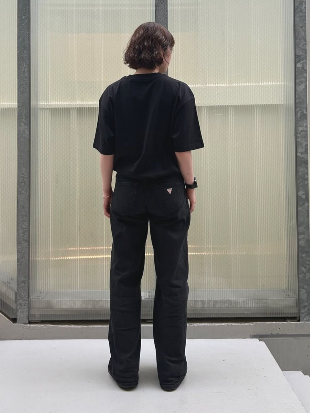 ブルー系のデニムパンツ、ブラック系のTシャツ/カットソーを着用したレディースの夏コーディネートの2枚目の写真