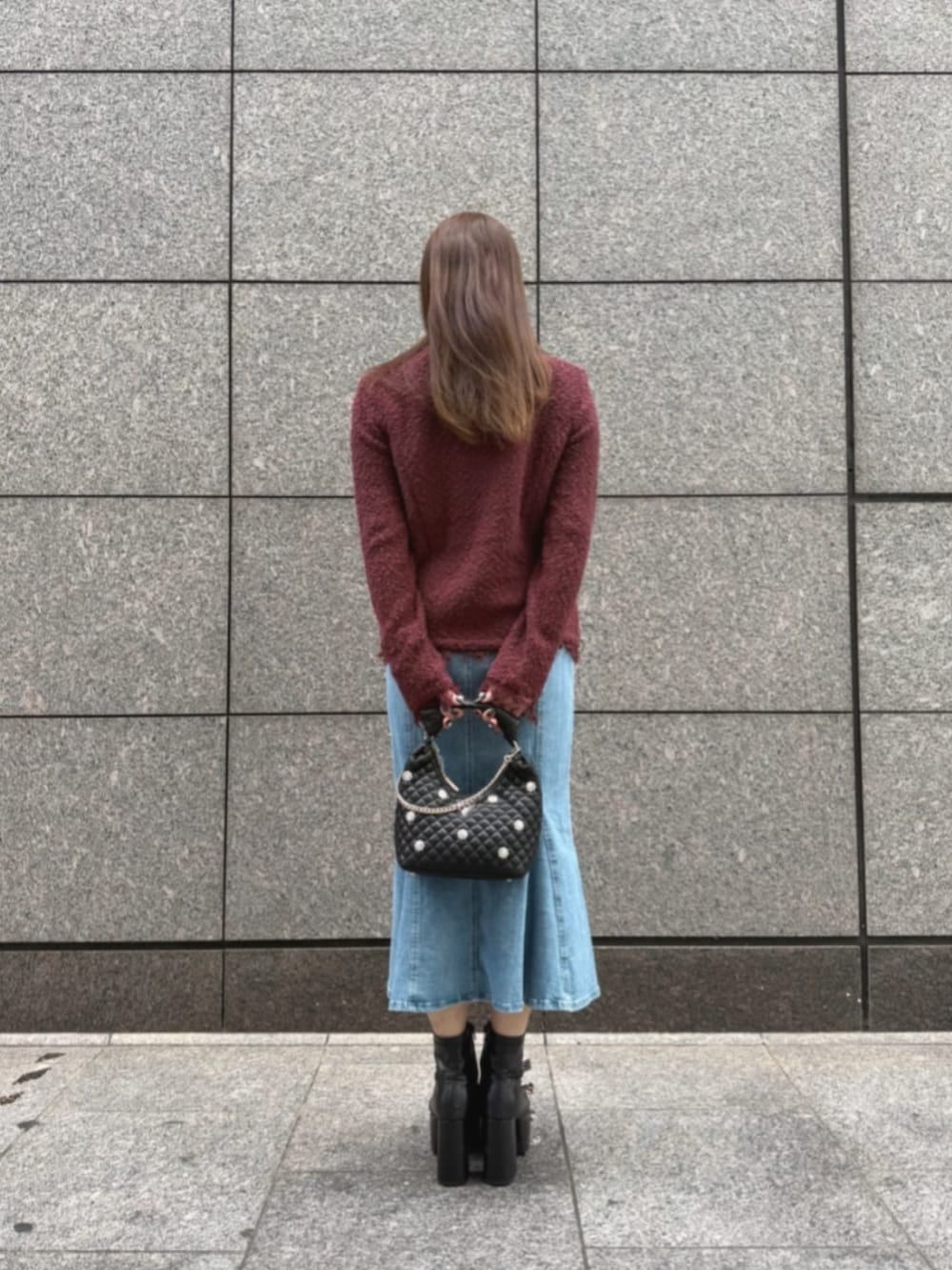 ブラック系のショルダーバッグ、ブルー系のデニムスカート、レッド系のノーカラージャケットを着用したレディースの秋コーディネートの2枚目の写真