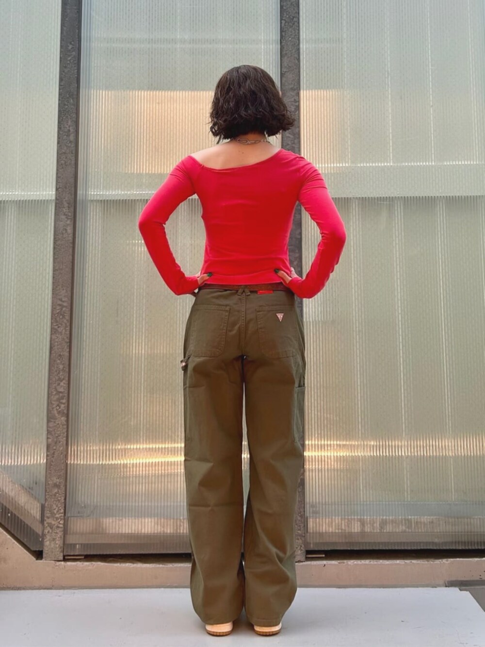 オレンジ系のTシャツ/カットソー、グリーン系のカーゴパンツを着用したレディースの夏コーディネートの2枚目の写真