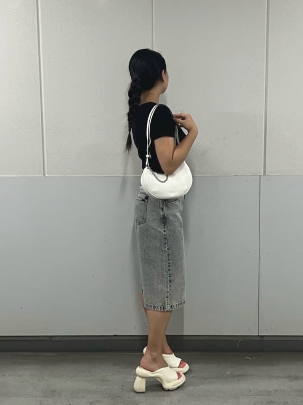 グレー系のデニムパンツ、ブラック系のTシャツ/カットソー、ホワイト系のハンドバッグを着用したレディースの夏コーディネートの3枚目の写真