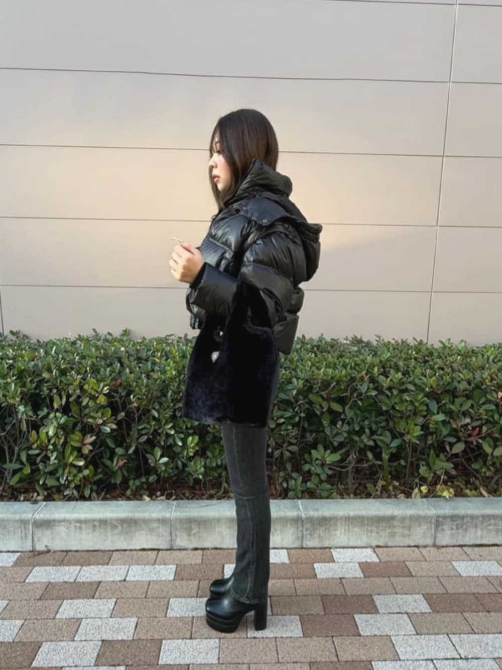 ブラック系のダウンジャケット/コート、ブラック系のショルダーバッグ、グレー系のTシャツ/カットソーを着用したレディースの冬コーディネートの3枚目の写真