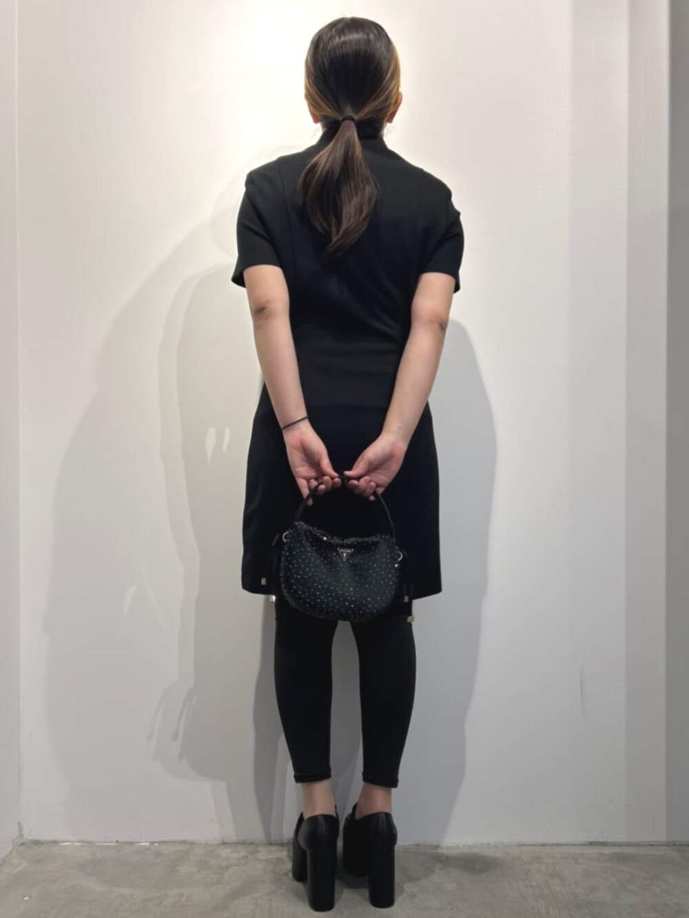 ブラック系のハンドバッグ、ブラック系のワンピースを着用したレディースの春コーディネートの2枚目の写真
