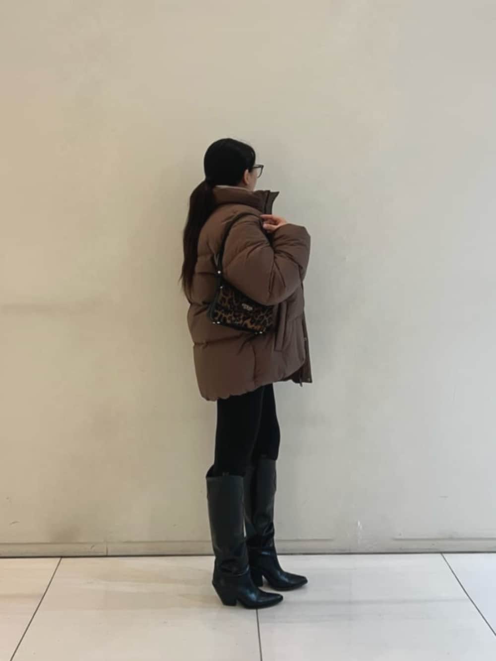 ブラウン系のダウンジャケット/コート、ベージュ系のニット/セーター、その他のハンドバッグを着用したレディースの冬コーディネートの3枚目の写真