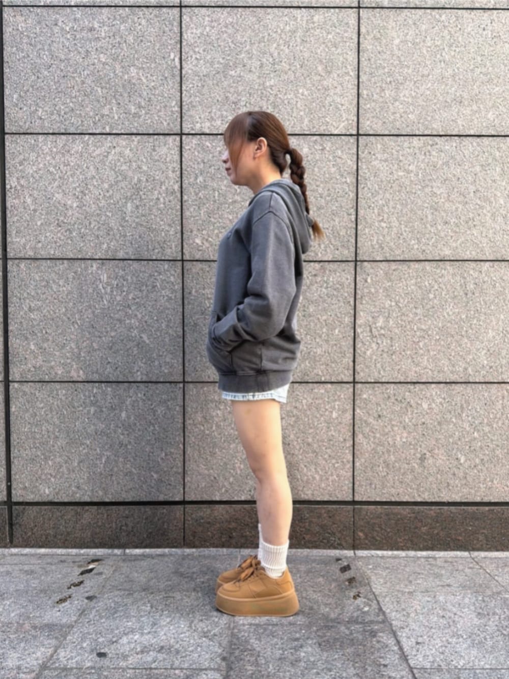 グレー系のパーカー、ブルー系のデニムパンツを着用したレディースの冬コーディネートの2枚目の写真